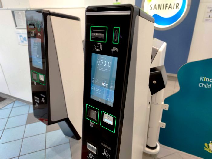 ein drehkreuz vor einer sanifair toilette. der preis steigt immer weiter