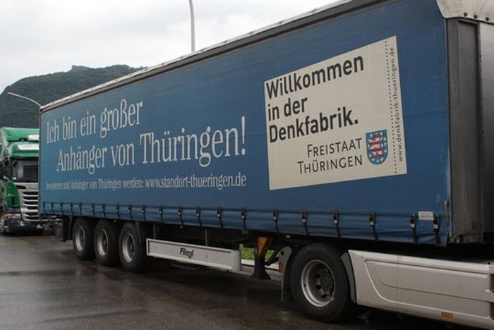 ein lkw auflieger mit werbung für den freistaat thüringen "willkommen in der denkfabrik". Thema unternehmer wollen, dass lkw-fahrer länger arbeiten. Raboti, raboti, fahrer
