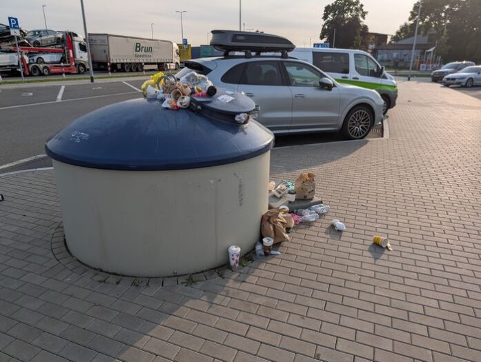überfüllte mülltonne auf einem autobahnraststätte