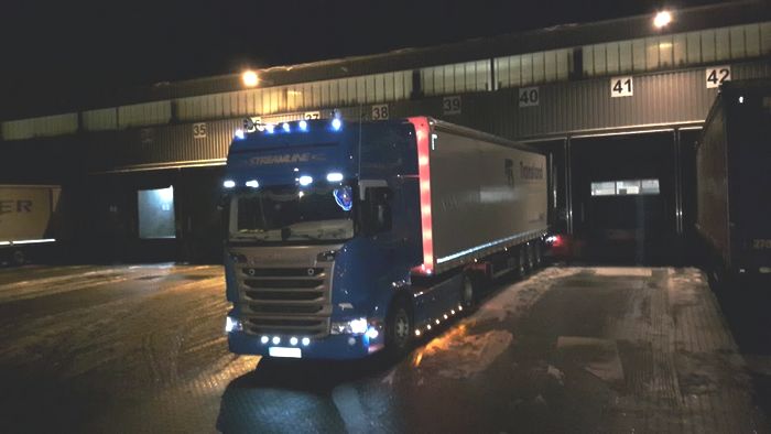 ein blauer lkw scania steht an einer rampe