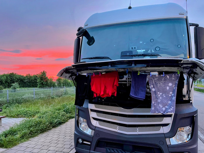 Ein Lkw steht auf einem Parkplatz und trocknet seine Wäsche am Kühlergrill 