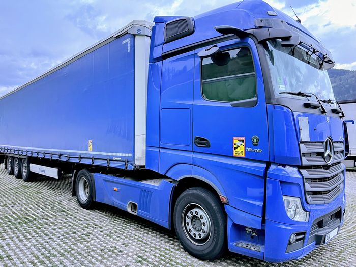 ein blauer mercedes lkw aus osteuropa steht auf einem parkplatz. deren fahrer sind auch von ausbeutung betroffen. 
