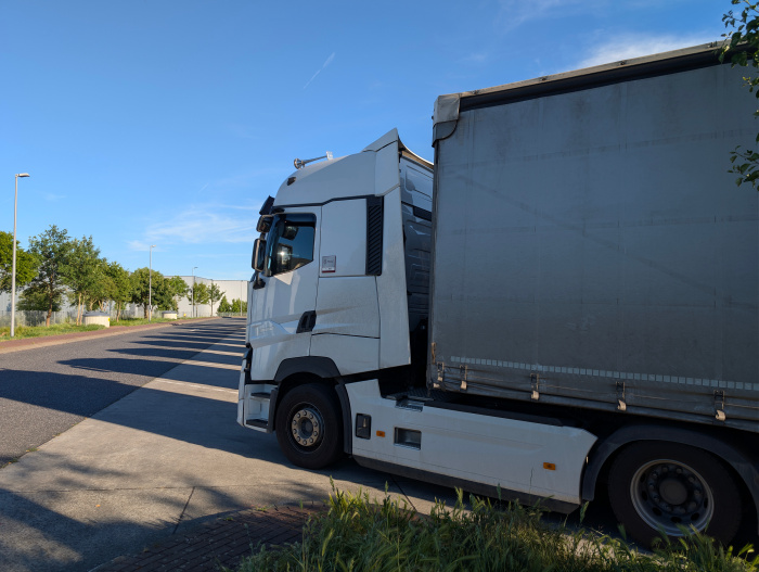 Ein Lkw Renault steht auf einem Rasthof. Der Fahrermangel wird durch Fachkräfte aus dem Ausland verringert.