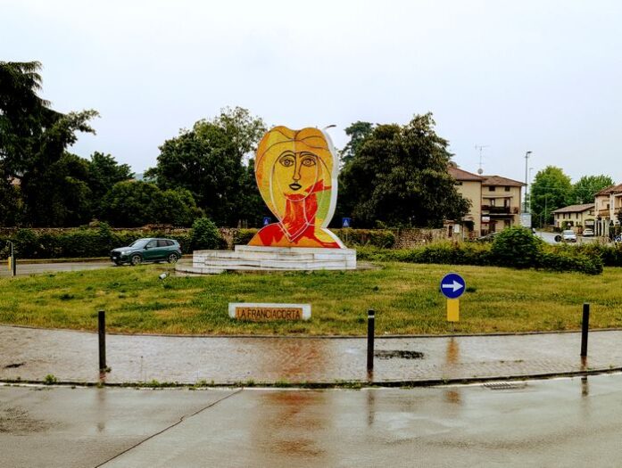 Ein Kreisverkehr im italienischen Adro mit einer Kunstfigur in der Mitte.